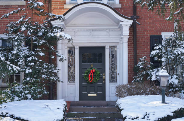 Traditional older brick house with portico entrance and Christmas decoration on front door stock photo