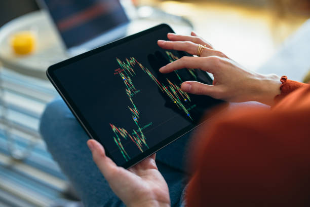 istock Home Office: An Anonymous Woman Using a Digital Tablet for Online Trading While Working From Home 1359884296