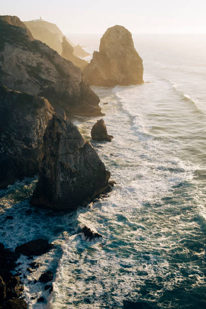 istock View from Miradouro da Praia do Caneiro, cliffs and surf in the Atlantic Ocean at sunset, Portugal. 1359887076