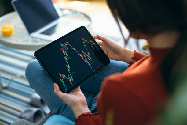 istock Home Office: An Anonymous Woman Using a Digital Tablet for Online Trading While Working From Home 1359890342