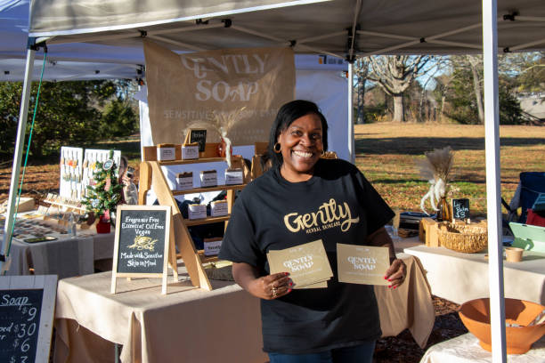 A vendor promotes a line of all-natural bath and body products for sensitive skin at the Indie South Annual Holiday Hurray market in Athens, Georgia stock photo