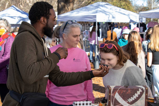 Jason Chappell demonstrates the Chalises line of natural bath and body products to customers at the Indie South Annual Holiday Hurray market in Athens, Georgia stock photo