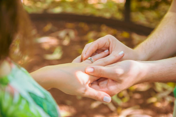 istock Boyfriend placing the engagement ring on his girlfriend's hand 1359894397