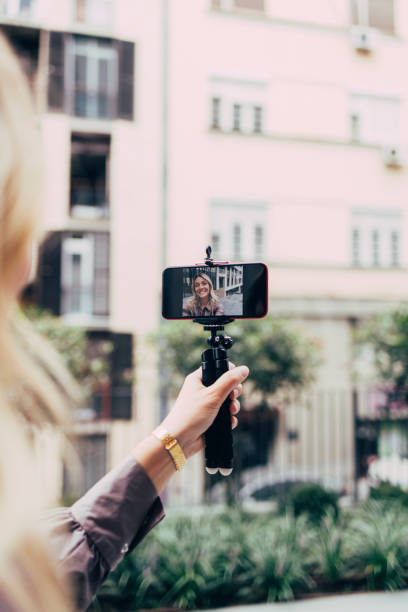 A Businesswoman Smiling While Making A  Video With Her Smartphone Which Is On The Stick