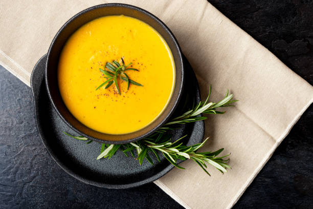 istock Pumpkin soup with linen napkin on dark background. 1359898306