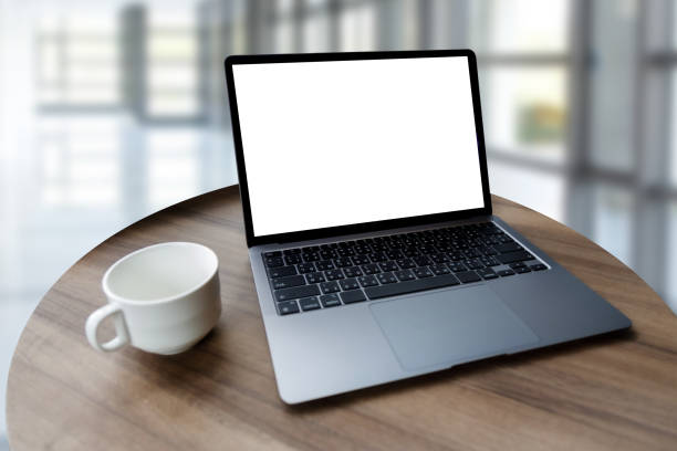 istock Blank screen laptop computer modern man use room laptop with blank white desktop screen with coffee cup on wooden table in cafe 1359900808