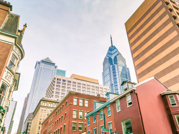 Philadelphia, Pennsylvania, USA - April 29, 2025: A sunny Philadelphia urban street lined with historic and modern buildings, cars, and pedestrians. The Convention Center Parking Facility.