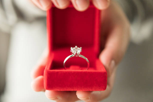 istock hands holding diamond ring in jewelry box 1359907260