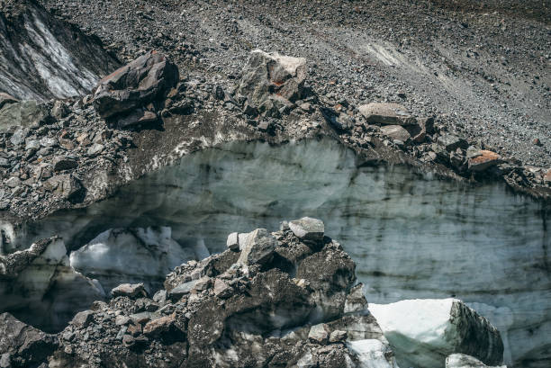 Nature background with icefall near glacier wall with cracks and scratches. Natural backdrop with icy wall and blocks of ice. Beautiful landscape with shiny glacial wall and ice blocks in sunlight.