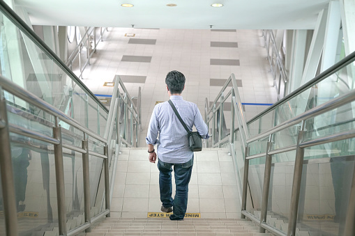 Man walking down the stairs inside a subway building. Commuter travel from work concept.