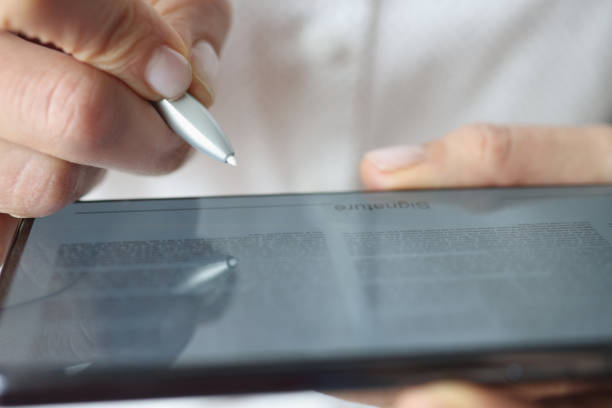 istock Man put signature on digital tablet device, open document and space for signing 1359908544