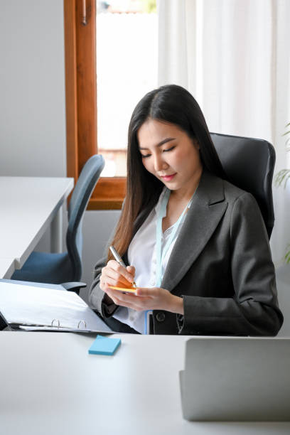 istock Female manager or business woman taking a notes on sticky notepad. 1359919118