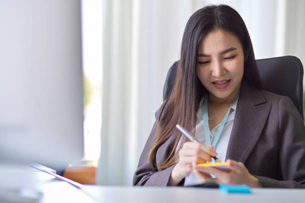 istock Businesswoman takes notes on a sticky note 1359919169