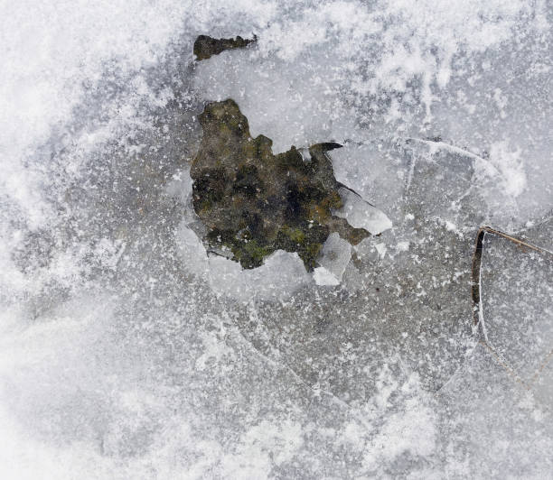 Top view texture of cracking broken ice pieces and frozen snow on ground during winter time, natural weather surface abstract photo.