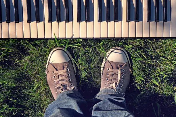 Toned Photo of Person and Piano Keyboard on the Green Grass