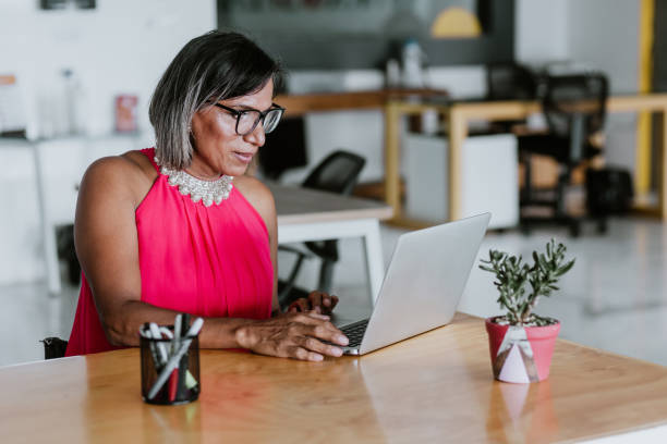 transgender latin woman working with computer at the office in Mexico Latin America transgender latin woman working with computer at the office in Mexico Latin America transgender person in office stock pictures, royalty-free photos & images