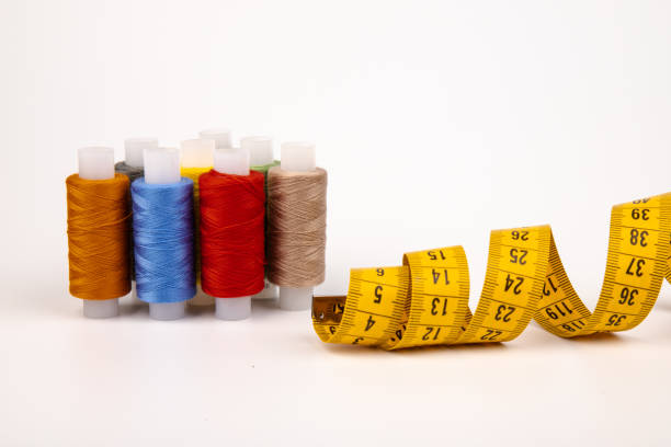 istock Sewing threads, sewing centimeter or measuring tape, isolated on white background. 1359936110