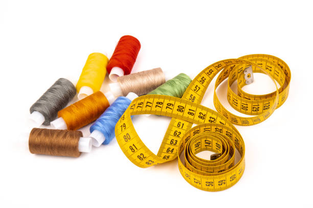istock Sewing threads, sewing centimeter or measuring tape, isolated on white background. 1359936254