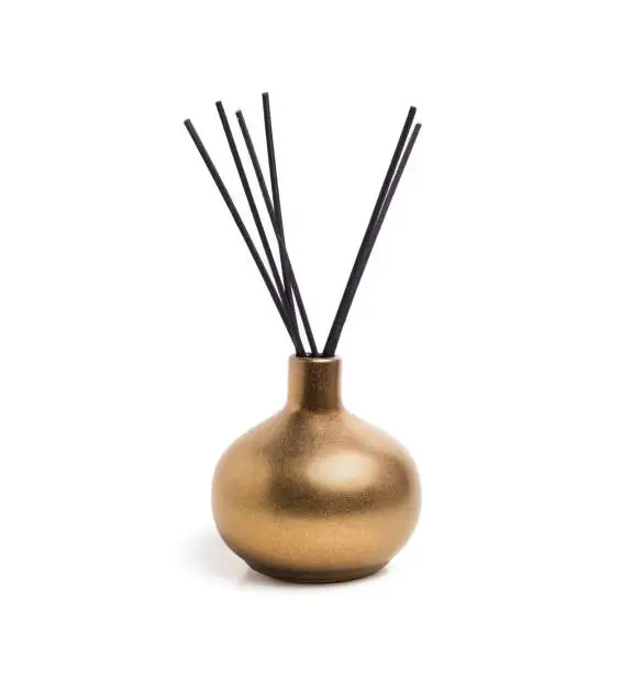 Shiny gold or yellow colored incense vase or incense burner with white background. Used during meditation, religious practice or freshen up the scents.