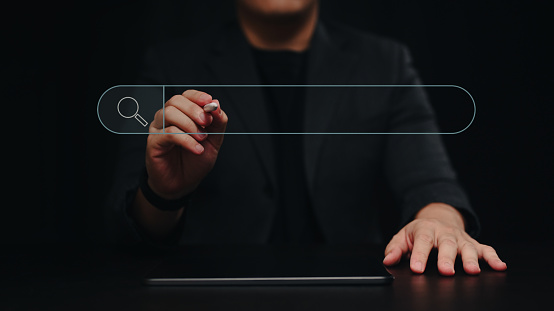 Businessman using digital tablet and holding stylus pen pressing on virtual screen of search bar button.