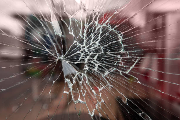 istock Bullet hole in the glass. Isolated on a black background. 1359942696