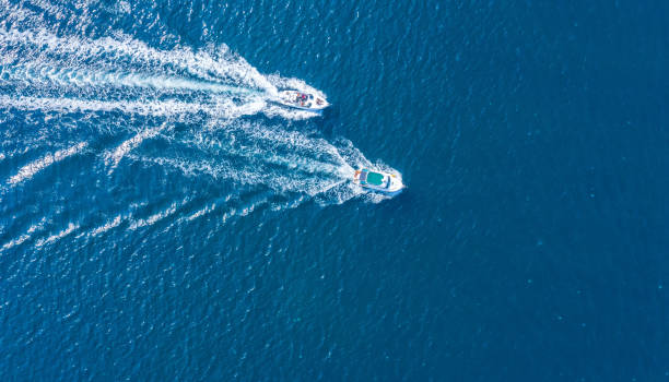 istock Two boats floating on the sea at high speed drone view. 1359945859