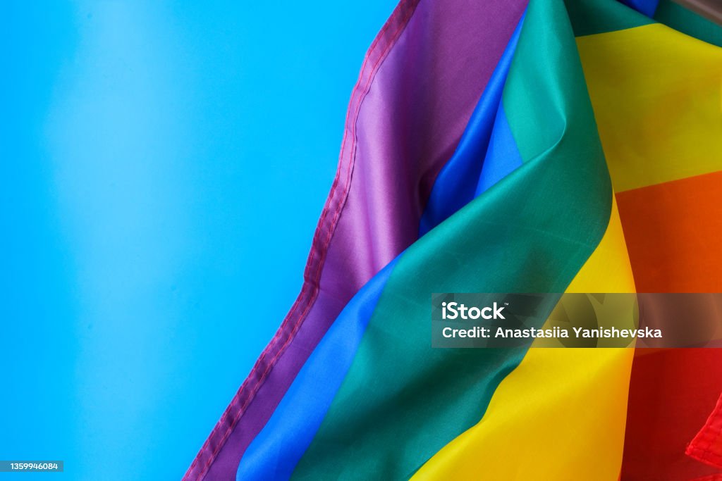 Rainbow flag on blue background with copy space. Rainbow lgbtq flag made from silk material. Symbol of LGBTQ pride month. Equal rights. Peace and freedom Rainbow flag on blue background with copy space. Rainbow lgbtq flag made from silk material. Symbol of LGBTQ pride month. Equal rights. Peace and freedom. Support LGBTQ community LGBTQIA Pride Month Stock Photo