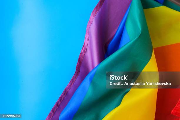 Rainbow Flag On Blue Background With Copy Space Rainbow Lgbtq Flag Made From Silk Material Symbol Of Lgbtq Pride Month Equal Rights Peace And Freedom Stock Photo - Download Image Now