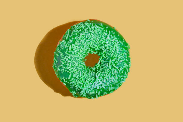 istock Green donut on a yellow background 1359946856