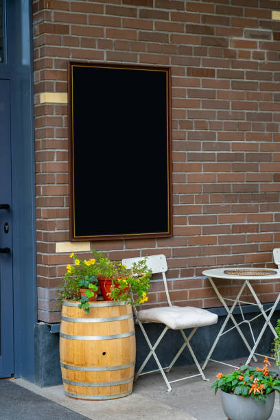 istock Empty menu board with table, potted plants and chair on street 1359948719