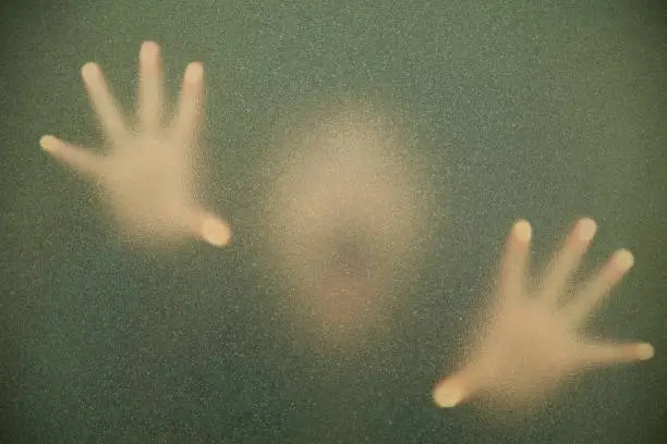diffused image of man through frosted glass