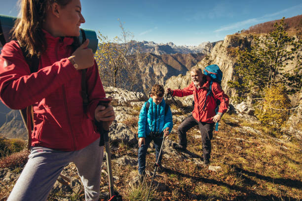 istock Father with two kids hiking in mountains 1359948960
