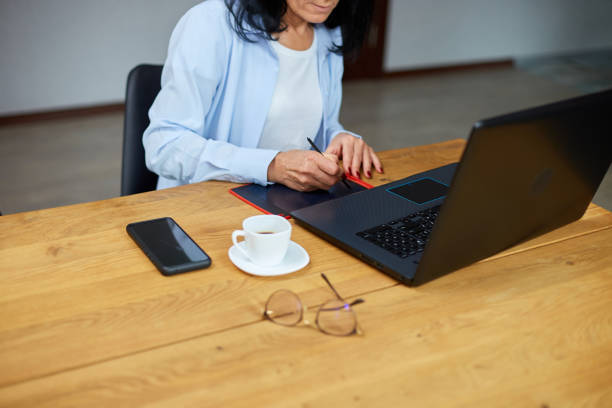 Mature woman designer using graphics tablet and stylus