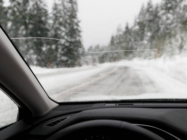 Car Windshield with Large Crack POV Winter Driving stock photo