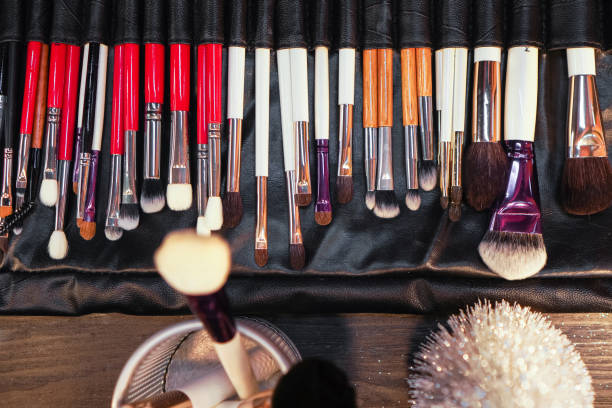 istock Set of makeup stylist brushes. Different makeup brushes in black leather case. Top view 1359955910