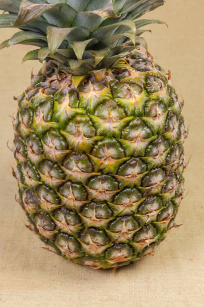 Whole fresh pineapple on a fabric surface, close-up