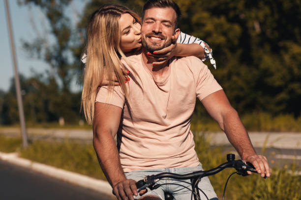 istock Cheerful young couple having fun riding bicycle. 1359961959