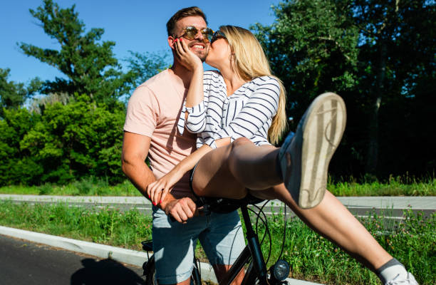 istock Cheerful young couple having fun riding bicycle. 1359962107