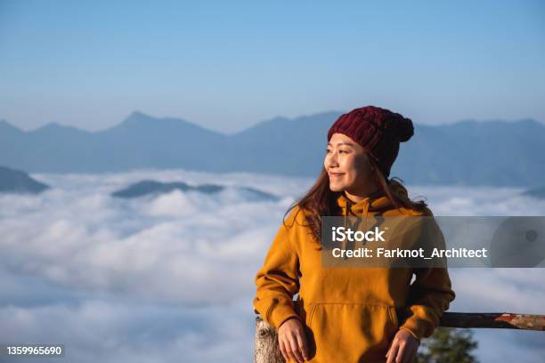 Portrait Of A Young Female Traveler With A Beautiful Mountain And Sea Of Fog In The Morning Stock Photo - Download Image Now