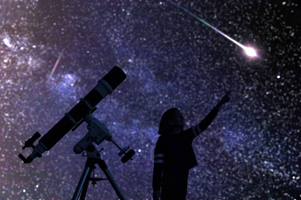 istock Girl with astronomical telescope stargazing under starry sky. 1359966742