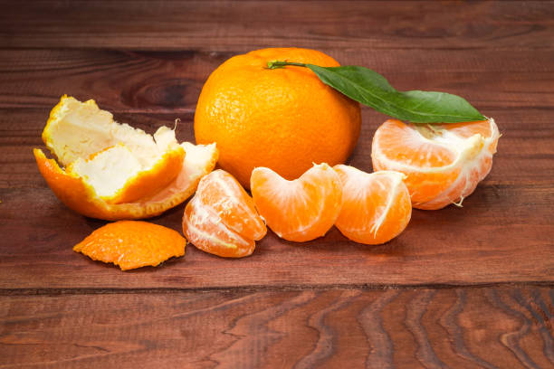 istock One whole and peeled tangerines on the old rustic table 1359967132