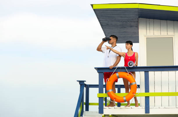 istock Lifeguards with megaphone and binocular on watch tower against blue sky 1359971875