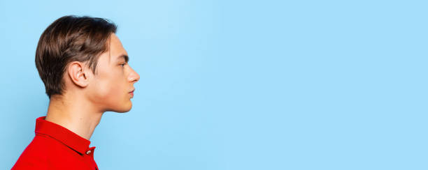 istock Profile view of young handsome man, student looking straight isolated on blue studio background. Flyer 1359973905