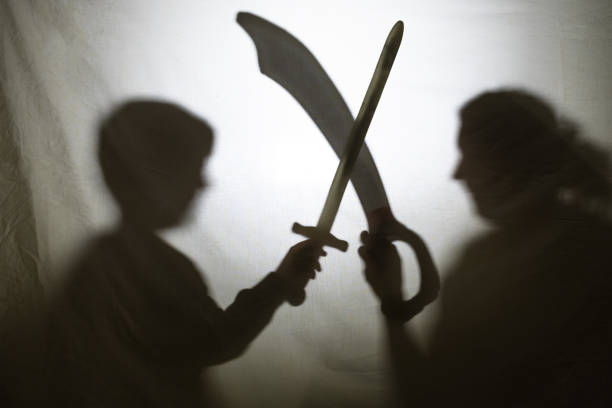 Mother and son playing with shadows behind a bed sheet