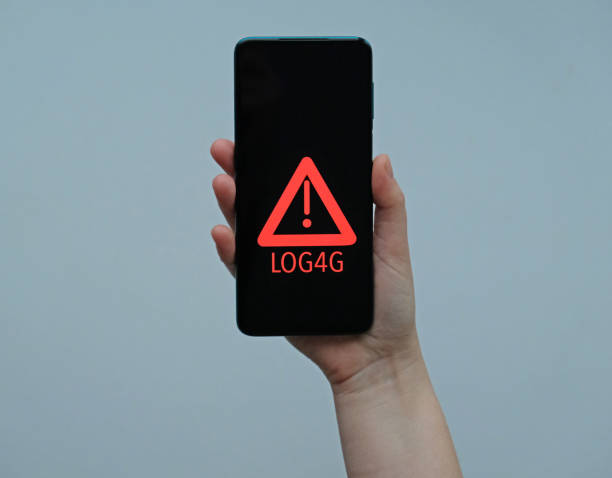 istock Smartphone in hand Security Vulnerability Log4J. Security vulnerability Log4j. The concept of cyber crime, cybersecurity and information security incidence. Cyber attack and crime. 1359977789