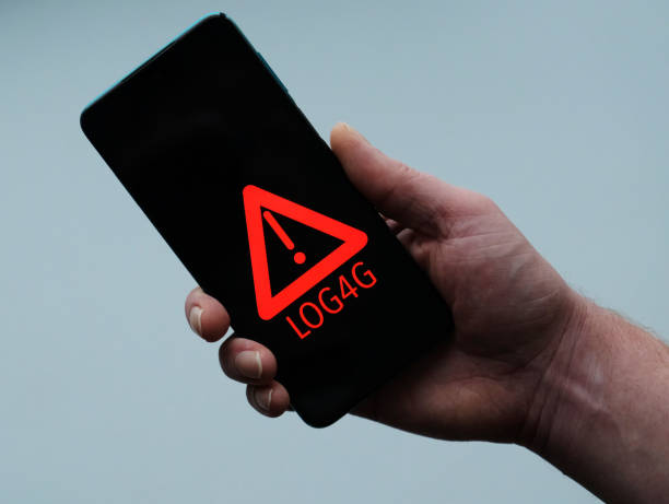 istock Smartphone in hand Security Vulnerability Log4J. Security vulnerability Log4j. The concept of cyber crime, cybersecurity and information security incidence. Cyber attack and crime. 1359977805