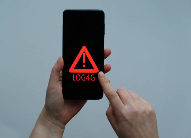 istock Smartphone in hand Security Vulnerability Log4J. Security vulnerability Log4j. The concept of cyber crime, cybersecurity and information security incidence. Cyber attack and crime. 1359977822