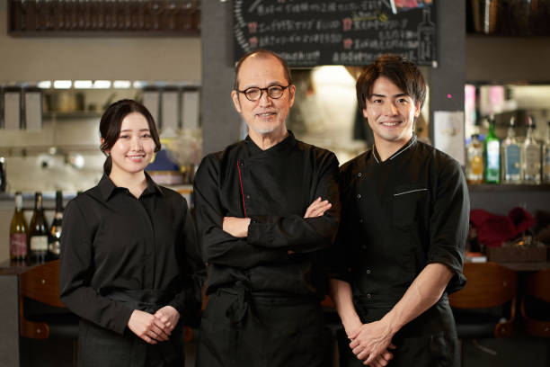 asiatische männer und frauen, die in restaurants arbeiten - restaurant chef gourmet dining stock-fotos und bilder
