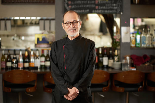 hombre asiático trabajando en un restaurante - pensionistas trabajadores fotografías e imágenes de stock