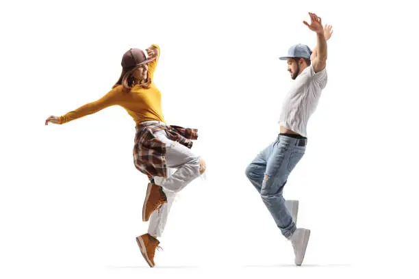 Photo of Full length profile shot of a guy and girl dancing hip hop